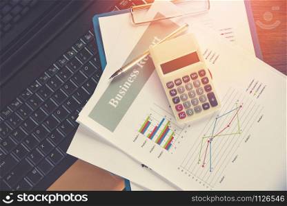Business report chart preparing graphs calculator on laptop / Summary report in Statistics circle Pie chart on paper business document financial chart and graph with pen on top view