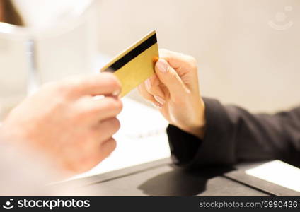 business, sale, payment and people concept - close up of customer hand giving credit card to seller or bank manager