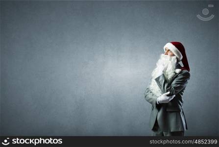 Business Santa. Thoughtful businessman in Santa hat with hand on chin