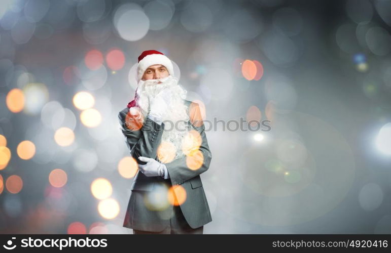 Business Santa. Thoughtful businessman in Santa hat with hand on chin