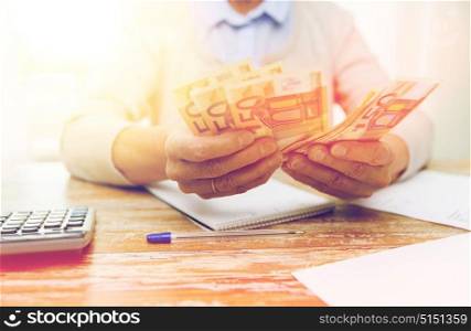 business, savings, annuity insurance, age and people concept - close up of senior woman with calculator and bills counting euro money at home. close up of senior woman counting money at home