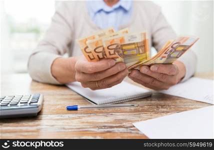 business, savings, annuity insurance, age and people concept - close up of senior woman with calculator and bills counting euro money at home