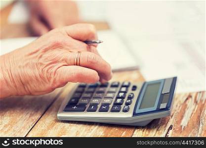 business, savings, annuity insurance, age and people concept - senior woman with calculator and papers counting at home