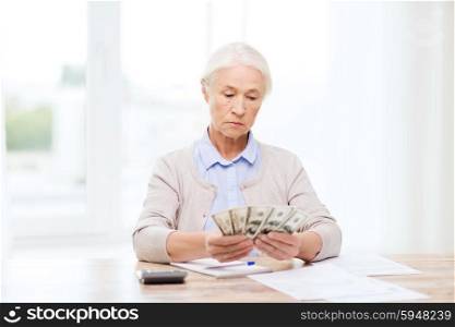 business, savings, annuity insurance, age and people concept - senior woman with calculator and bills counting dollar money at home