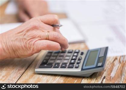 business, savings, annuity insurance, age and people concept - senior woman with calculator and papers counting at home