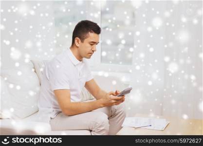 business, savings, finances and people concept - man with papers and calculator at home over snow effect