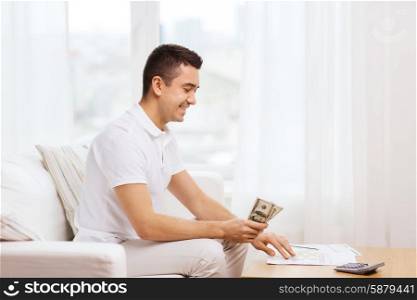 business, savings, finances, income and people concept - man with papers and calculator at home