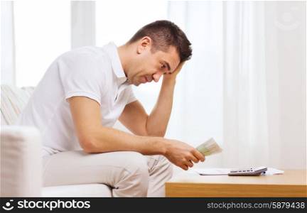 business, savings, financial crisis and people concept - man with money and calculator at home