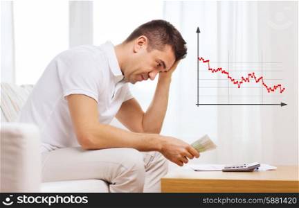 business, savings, financial crisis and people concept - upset man with money and calculator at home