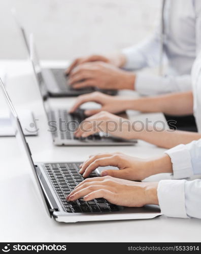 business, school and education concept - group of people working with laptops in office