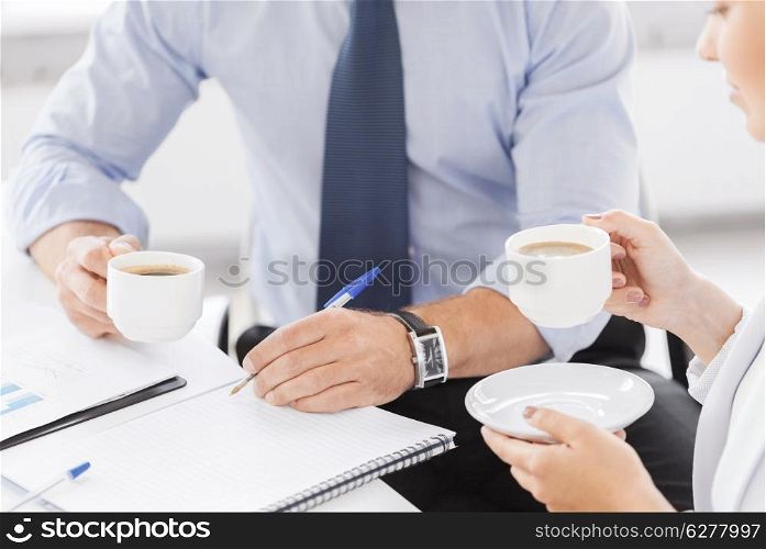 business, school and education concept - smiling businesswoman and businessman discussing something in office