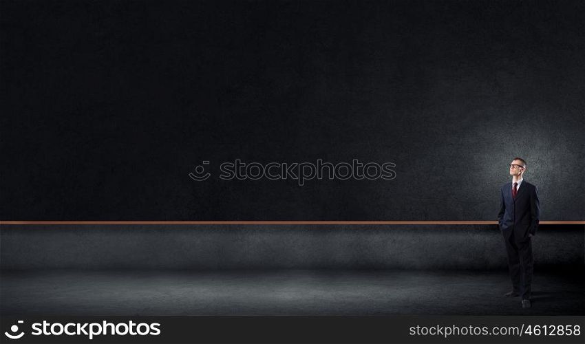 Business seminar. Young businessman in glasses and blank blackboard