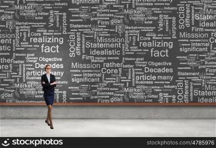 Business seminar. Young confident woman wearing glasses standing near blackboard
