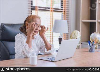 Business senior Asian Elder woman headache migraine sick from working looking at computer screen long time.