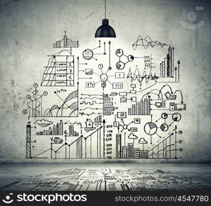 Business sketch on wall. Drawn business plan on wall illuminated by lamp above