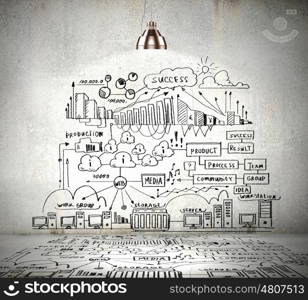 Business sketch on wall. Drawn business plan on wall illuminated by lamp above