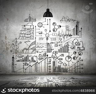 Business sketch on wall. Drawn business plan on wall illuminated by lamp above