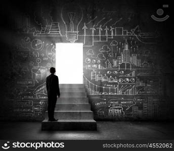 Business solution. Silhouette of businessman standing in doorway light