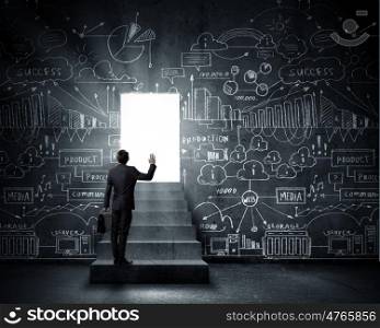 Business solution. Silhouette of businessman with briefcase standing in doorway