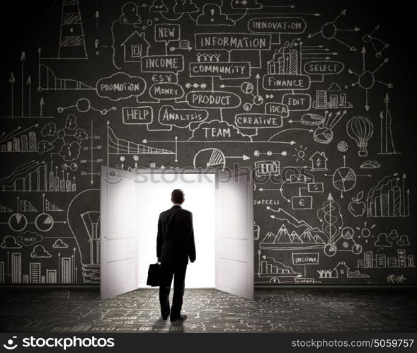 Business solution. Silhouette of businessman with briefcase standing in doorway