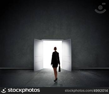 Business solution. Silhouette of businesswoman with briefcase standing in doorway