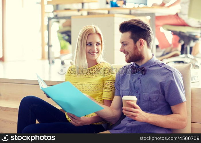 business, startup and people and concept - happy man and woman with folder drinking coffee and talking in office