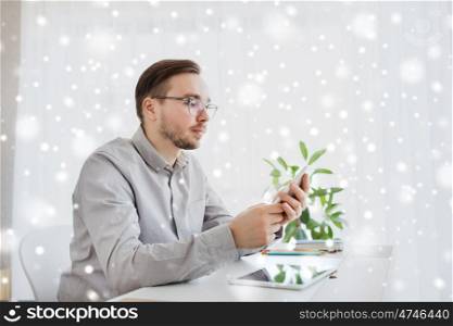 business, startup and people concept - businessman or creative male worker texting on smartphoneat home office over snow