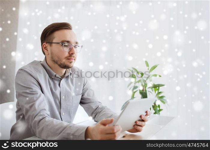business, startup and people concept - businessman or creative male worker with tablet pc computer at home office over snow