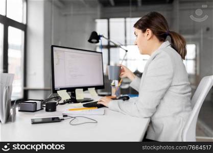 business, startup and people concept - businesswoman with computer and coffee working at office. businesswoman with computer and coffee at office