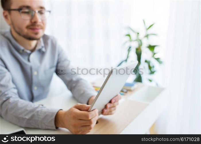 business, startup and people concept - close up of happy businessman or creative male office worker with tablet pc computer at home office