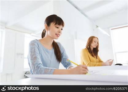 business, startup and people concept - creative or architect woman with blueprint writing on sticker at office