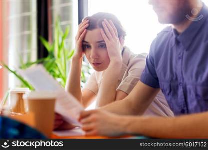 business, startup and people concept - creative team of man and woman with computer and files solving problem in office