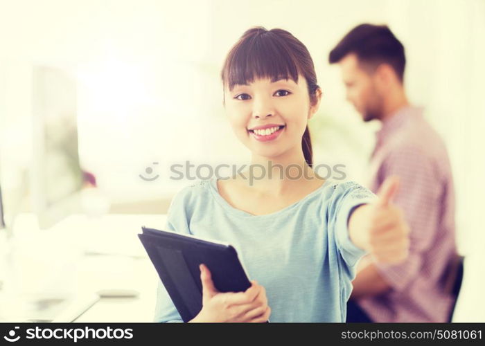 business, startup and people concept - happy asian businesswoman or creative female office worker with tablet pc computer showing thumbs up. happy creative female office worker with tablet pc