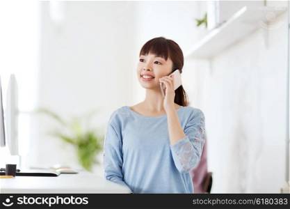 business, startup and people concept - happy asian businesswoman or creative worker calling on smartphone at office