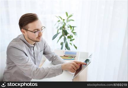 business, startup and people concept - happy businessman or creative male office worker with tablet pc computer at home office