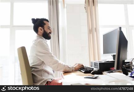 business, startup and people concept - happy businessman or creative male office worker with computer