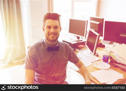 business, startup and people concept - happy businessman or creative male office worker with computers