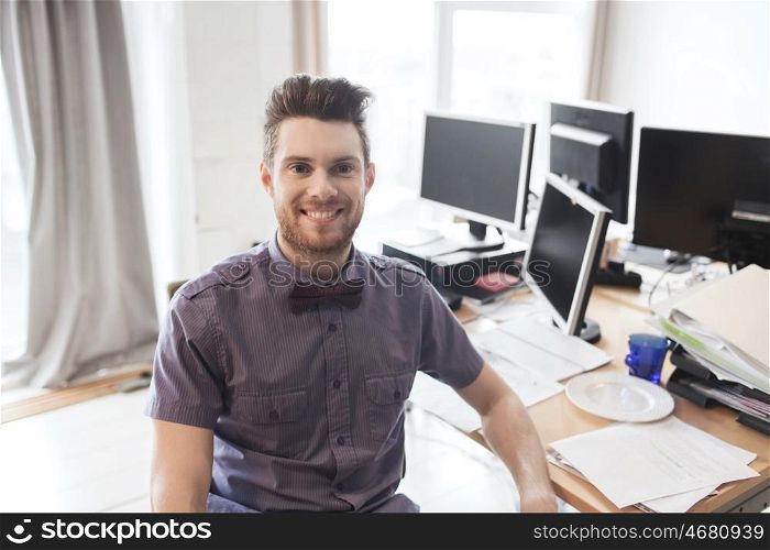 business, startup and people concept - happy businessman or creative male office worker with computers