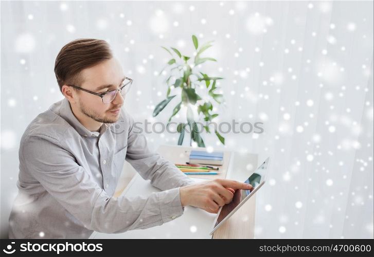 business, startup and people concept - happy businessman or creative male worker with tablet pc computer at home office over snow