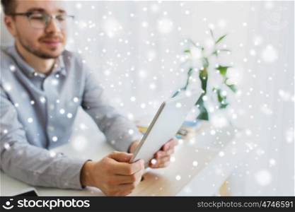 business, startup and people concept - happy businessman or creative male worker with tablet pc computer at home office over snow