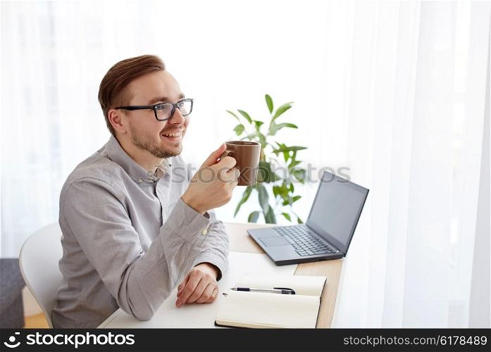 business, startup and people concept - happy businessman or creative male worker with notebook or diary drinking coffee at home office