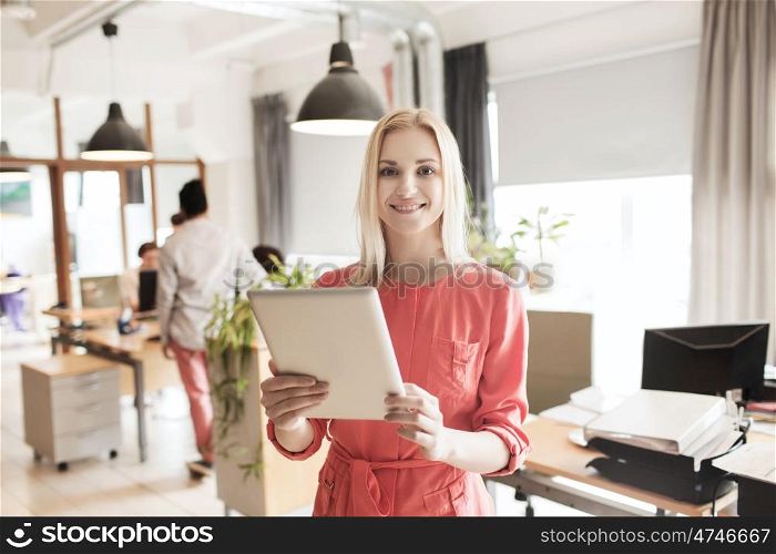 business, startup and people concept - happy businesswoman or creative female office worker with tablet pc computer. happy creative female office worker with tablet pc