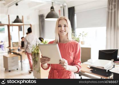business, startup and people concept - happy businesswoman or creative female office worker with tablet pc computer. happy creative female office worker with tablet pc