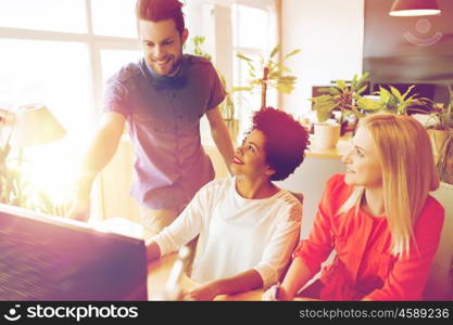 business, startup and people concept - happy creative team networking with computer in office