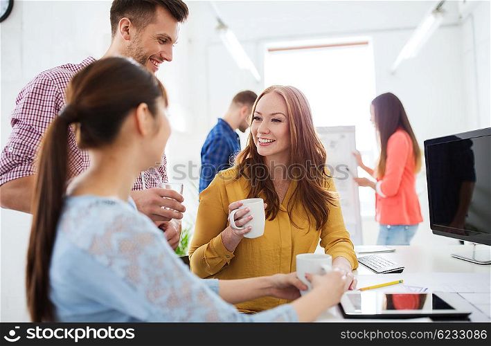 business, startup and people concept - happy creative team or students drinking coffee at office