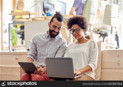 business, startup and people concept - happy creative team with laptop and tablet pc computer in office