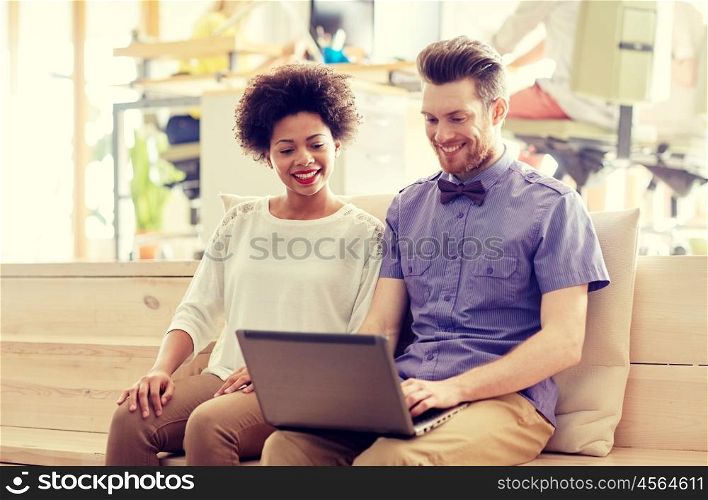 business, startup and people concept - happy creative team with laptop computer and folder in office