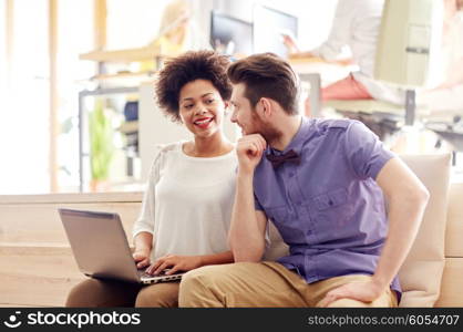 business, startup and people concept - happy creative team with laptop computer in office