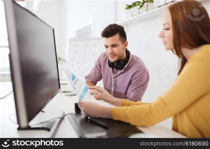 business, startup and people concept - happy creative team with papers and computer at office