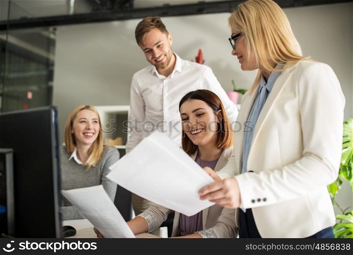 business, startup and people concept - happy creative team with papers in office